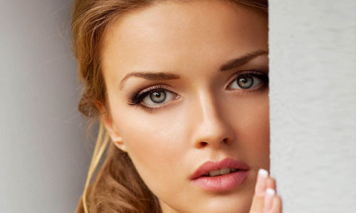 Close-up picture of a beautiful woman, happy with her eyelid lift in Cabo San Lucas, Mexico.  The woman has medium length brown hair and is looking directly at the camera.