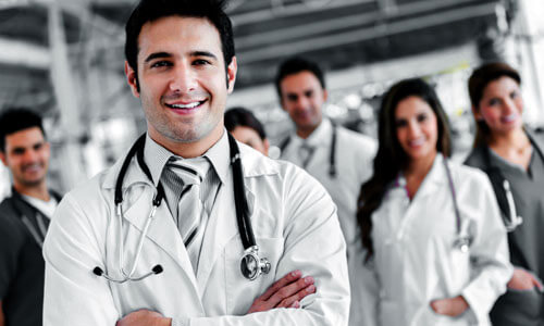 Picture of a group of doctors and assistants representing top plastic surgeons in Cabo San Lucas, Mexico.  Five are standing in the back and one is standing in front of them with arms folded.